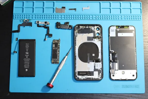 Componentes de iPhone desmontados em bancada de reparo